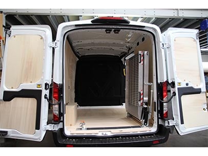 Rampe utilitaire rangée sur le côté du véhicule, optimisation de l’espace intérieur et accès libre à la zone de chargement.